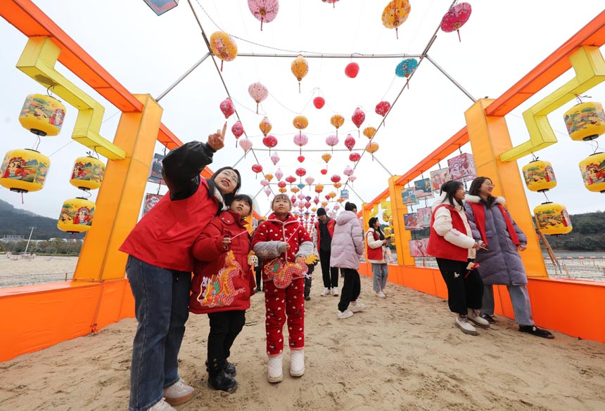 东乡区佛岭国际公园，青年志愿者带着留守儿童一起赏花灯。饶方其摄
