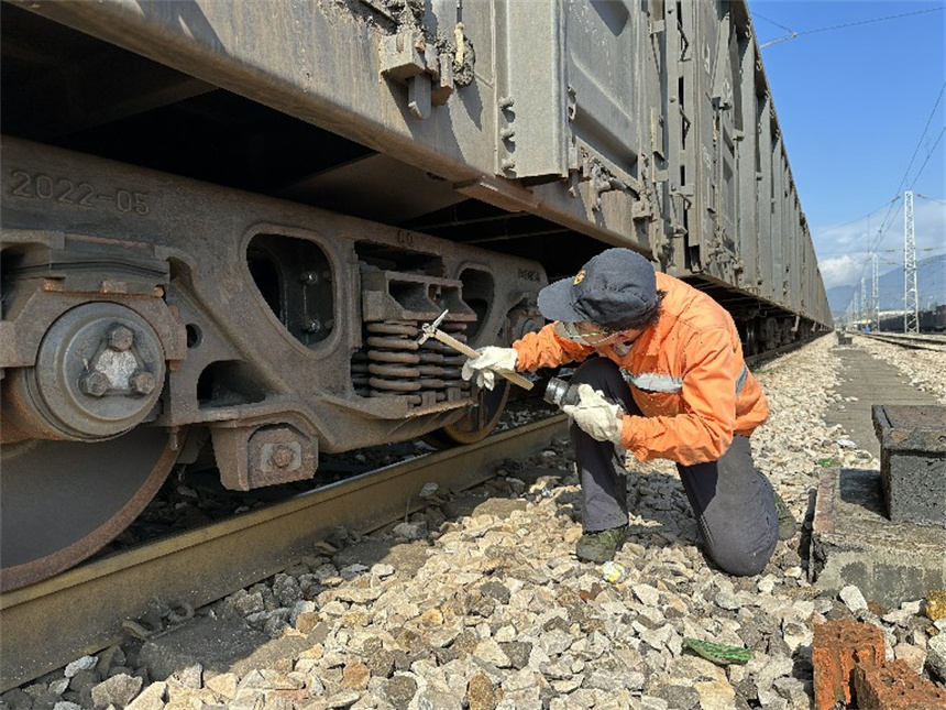 工作人員在檢查車輛枕簧。覃澤誠攝