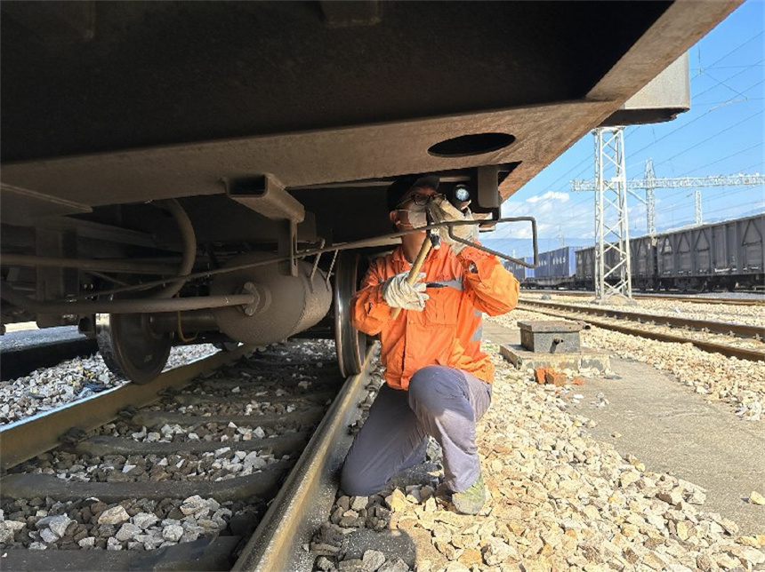 工作人員在檢查車輛緩解閥拉杆吊架。覃澤誠攝