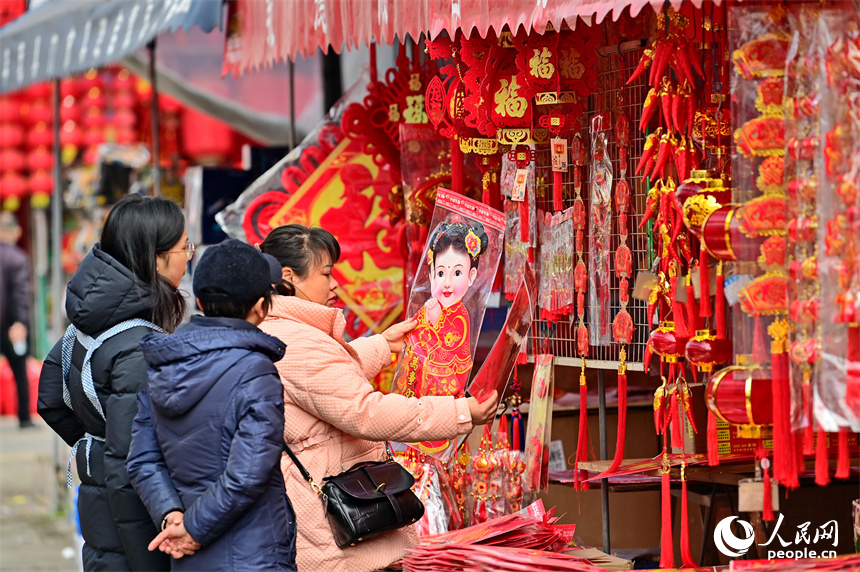 赣州市赣南贸易广场的喜庆饰品店，市民在选购春联、灯笼、福字。人民网 朱海鹏摄