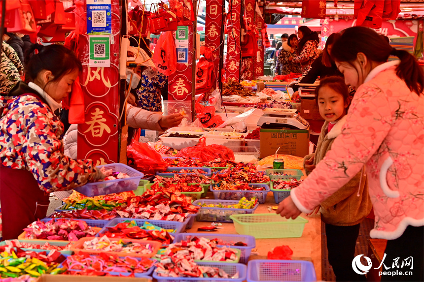 赣州市赣南贸易广场的喜庆饰品店，市民在选购春联、灯笼、福字。人民网 朱海鹏摄