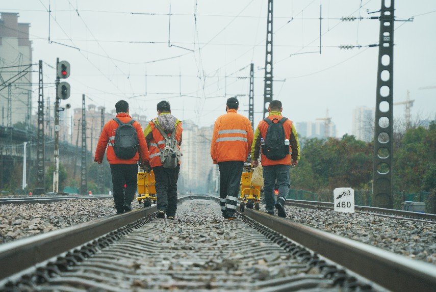 探伤人员推行钢轨探伤车行走在铁路线路上。黄钟滨摄