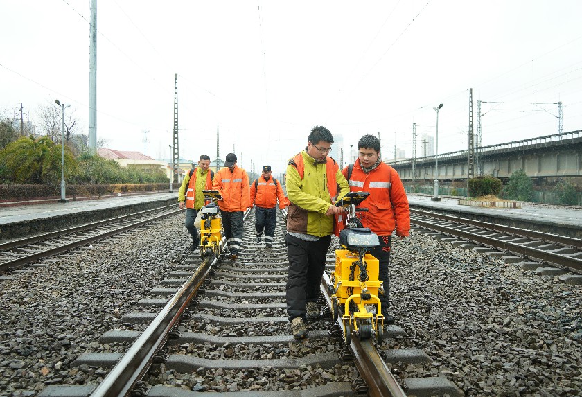 5.图为探伤人员推行钢轨探伤车行走在铁路线路上，对线路进行探伤作业。黄钟滨 摄