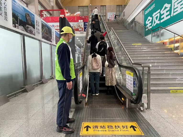 漳州车务段志愿者“青小柠”在候车室做好旅客乘坐扶梯防护。陈柯添摄