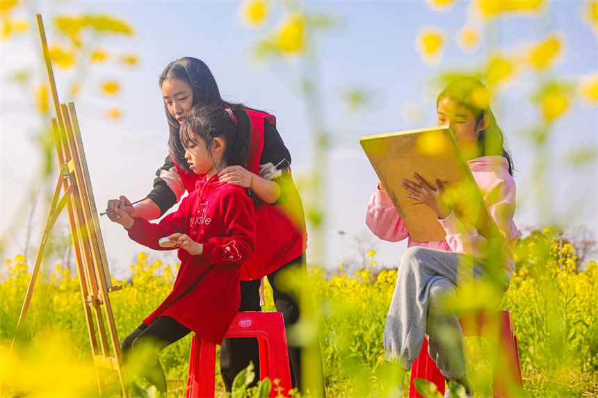 孩子們在油菜花地裡作畫。李煜祖攝