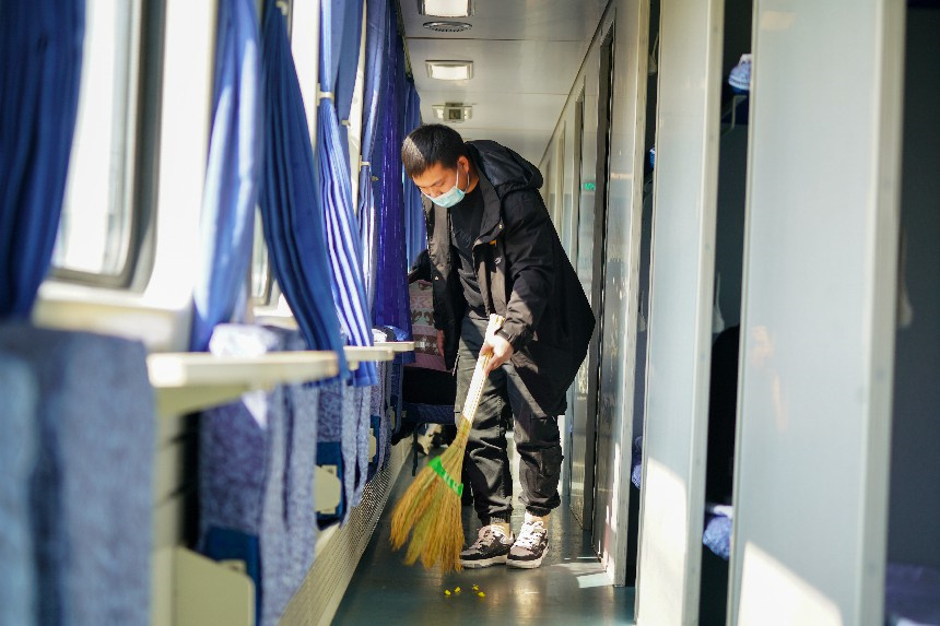 萍鄉工務段青年職工李闖正在車廂內打掃衛生，確保旅客的回家之途干淨清爽。梁犇攝