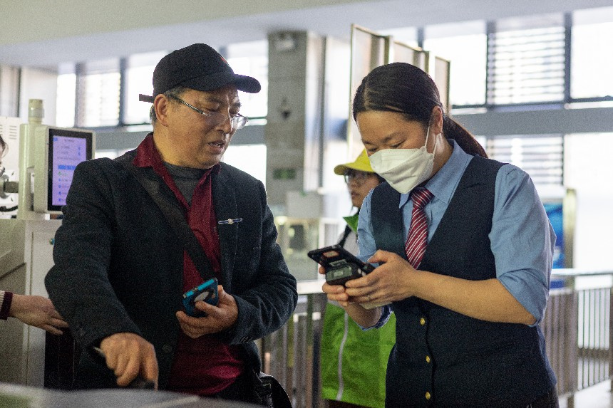 鹰潭站客运值班员李佳林利用手持检票机帮助旅客快速检票。蔡紫妍摄