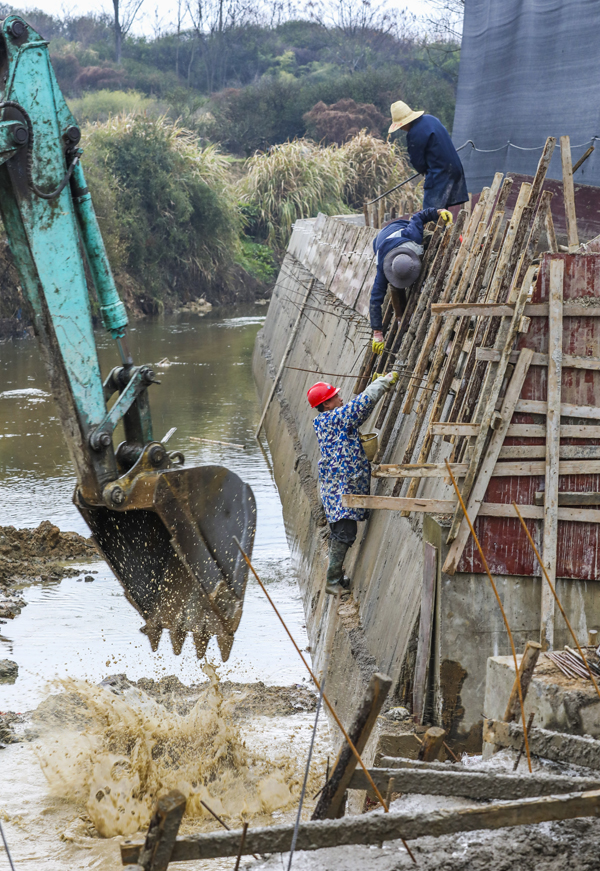3月4日，南豐縣洽灣鎮西坪村，工人在進行河道疏浚、堤防加固等作業。謝東攝