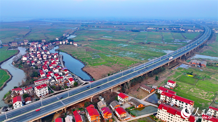 南昌县南新乡西江村，车辆在绕城高速公路上疾驰，沿线乡村春景怡人。人民网 朱海鹏摄