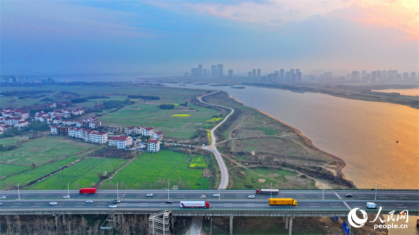 南昌县南新乡西江村，车辆在绕城高速公路上疾驰，沿线乡村春景怡人。人民网 朱海鹏摄