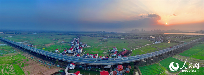 南昌县南新乡西江村，车辆在绕城高速公路上疾驰，沿线乡村春景怡人。人民网 朱海鹏摄