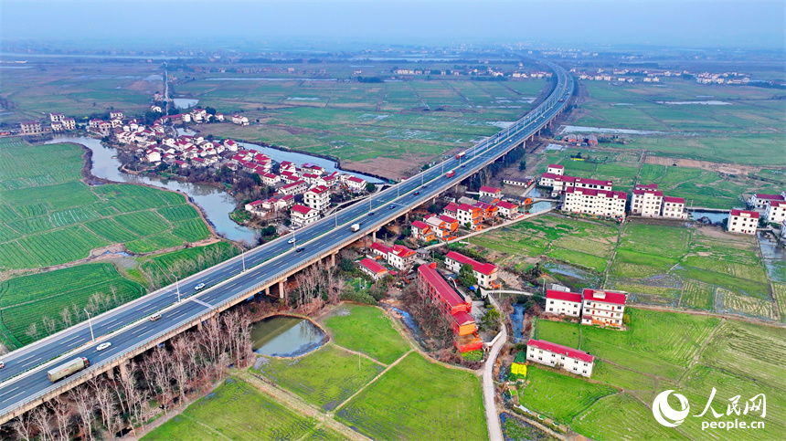 南昌县南新乡西江村，车辆在绕城高速公路上疾驰，沿线乡村春景怡人。人民网 朱海鹏摄