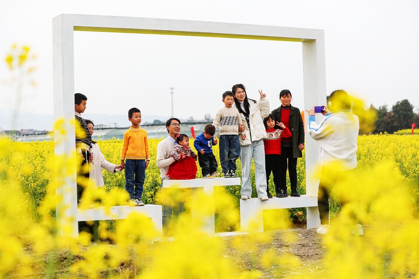 游客正在江西省抚州市广昌县头陂镇龙虎村油菜花田里赏花拍照。曾恒贵摄