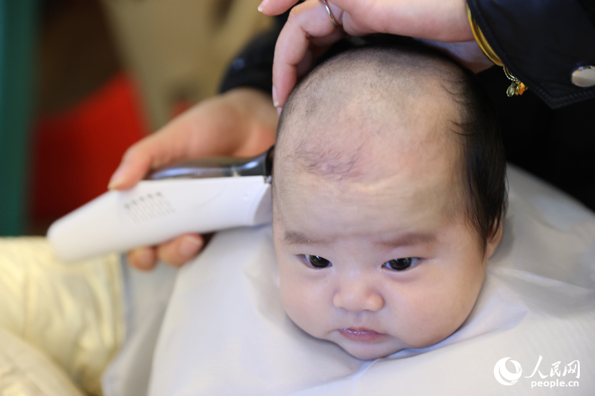 二月二“龙抬头”，理发师正在给孩子理发。 人民网记者 时雨摄