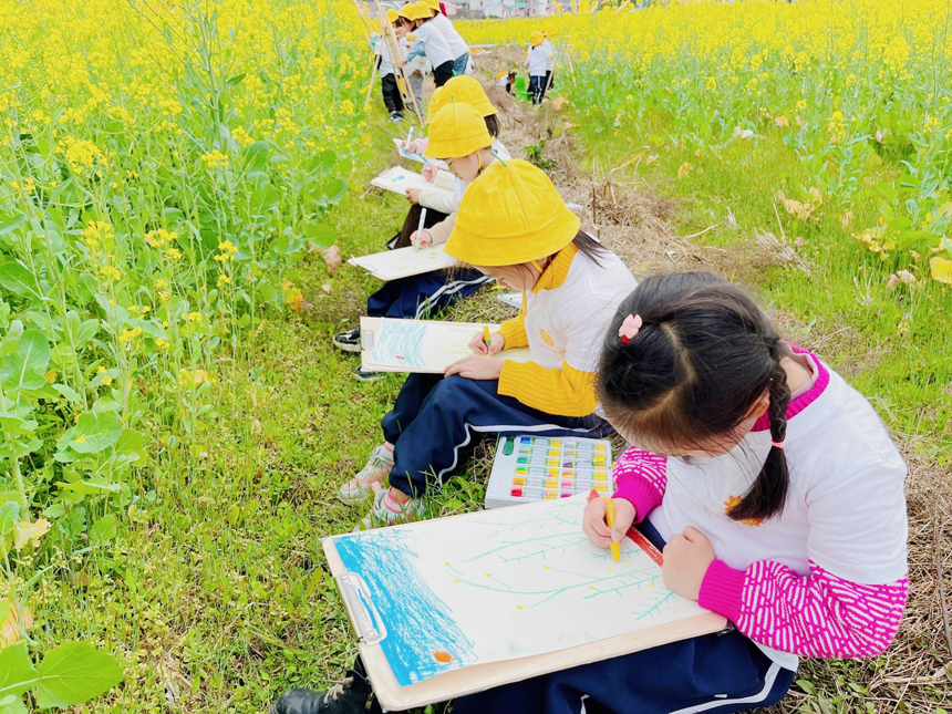 小朋友们在田埂上作画，绘出油菜花海的专属浪漫。李禹洪摄