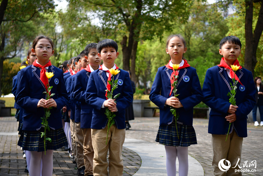 學生們手持菊花祭奠先烈。 人民網記者 時雨攝