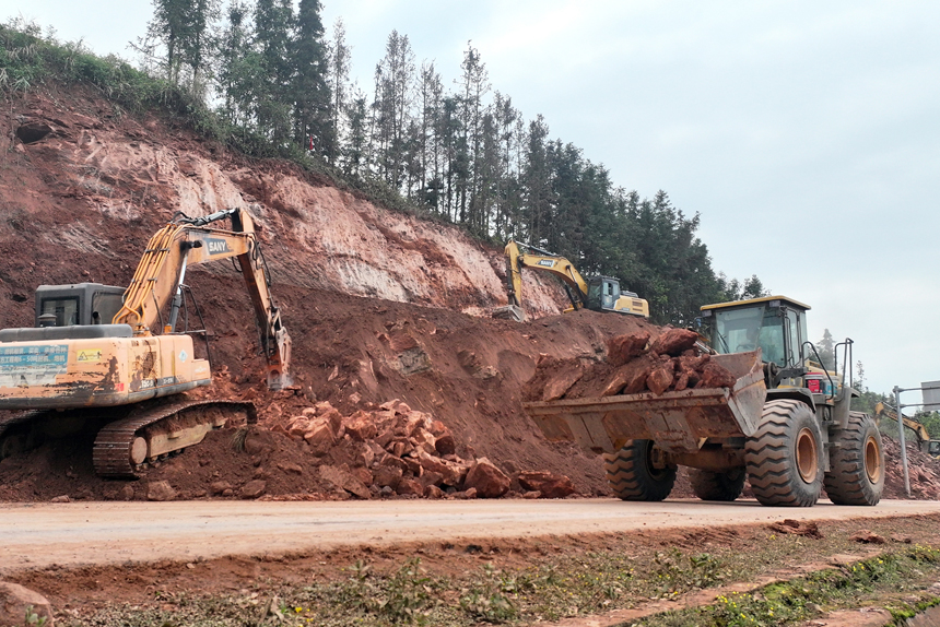 宜丰公路分中心施工队伍对崩塌的岩石山体进行削坡缷载，确保道路安全畅通。何贱来摄