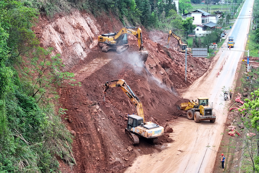 宜丰公路分中心施工队伍对崩塌的岩石山体进行削坡缷载，确保道路安全畅通。何贱来摄