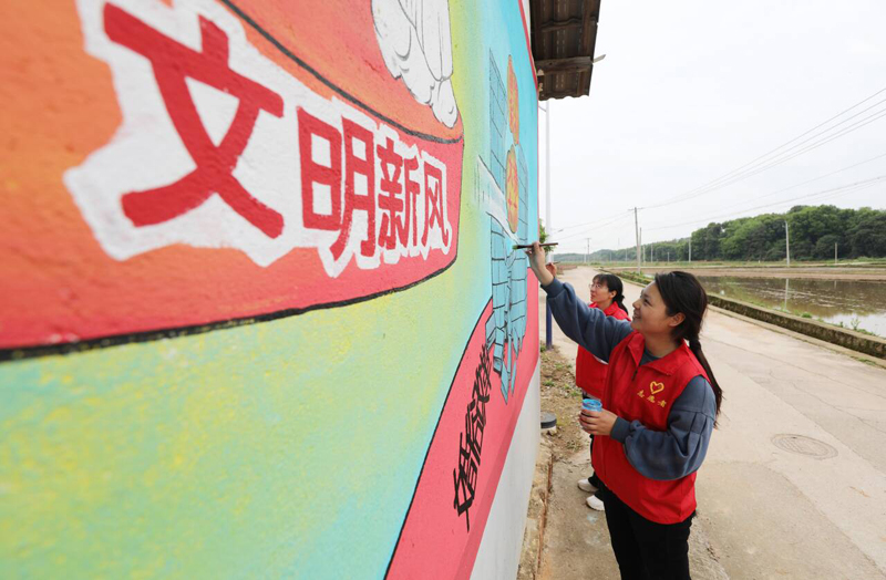 江西省撫州市東鄉區珀玕鄉筆村村，黨員志願者正在描繪牆畫。 饒方其攝