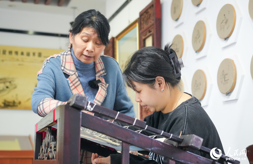 陶永红正在指导她的徒弟刺绣。人民网 孔文进摄