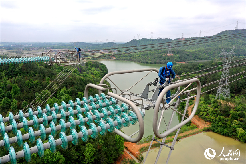 國網江西電力有限公司的檢修人員正在雅湖特高壓電網上走線進行年度檢修作業。 人民網記者 時雨攝