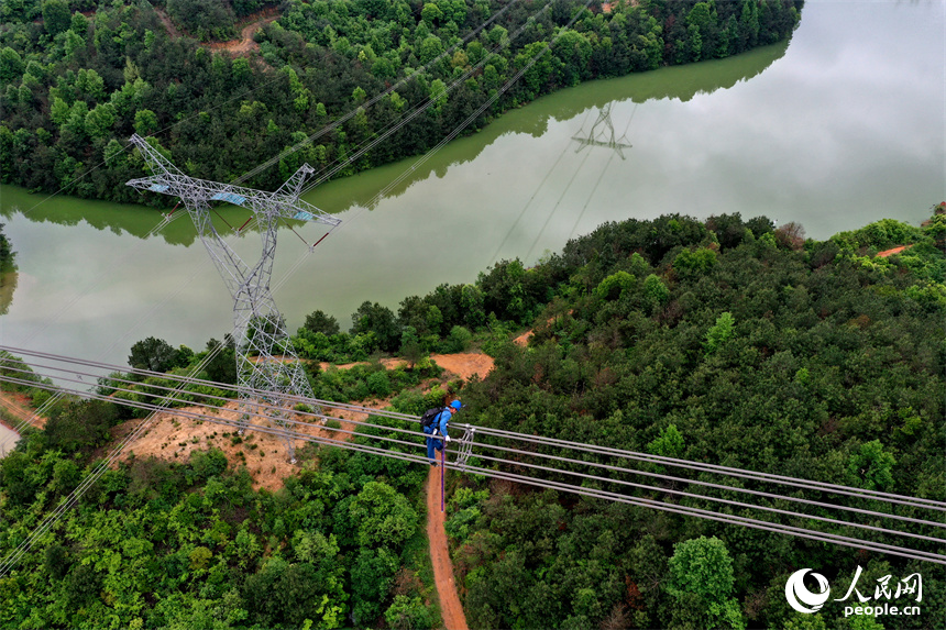 國網江西電力有限公司的檢修人員正在雅湖特高壓電網上走線進行年度檢修作業。 人民網記者 時雨攝