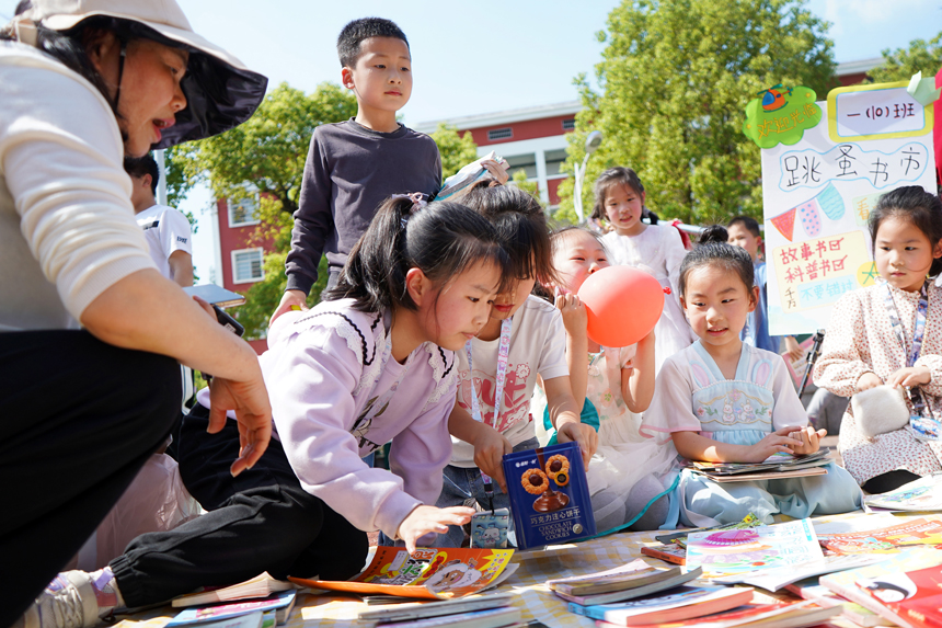 4月23日，上高县敖阳小学的孩子们在校园内“图书跳蚤市场”挑选自己喜爱的图书。陈旗海摄