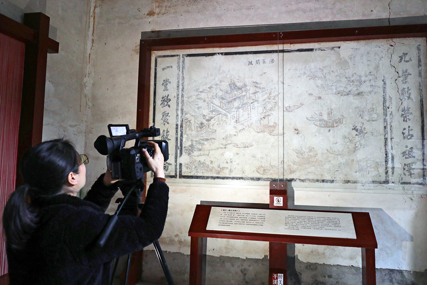 媒体记者在宜丰县天宝乡平溪村老屋改造的村史馆拍摄清代壁画《滕王阁图》。何贱来摄