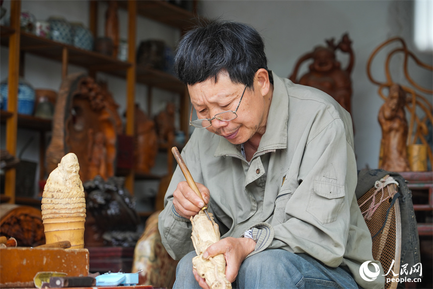 江西省级非遗项目根雕代表性传承人刘四喜在创作根雕作品。人民网 孔文进摄