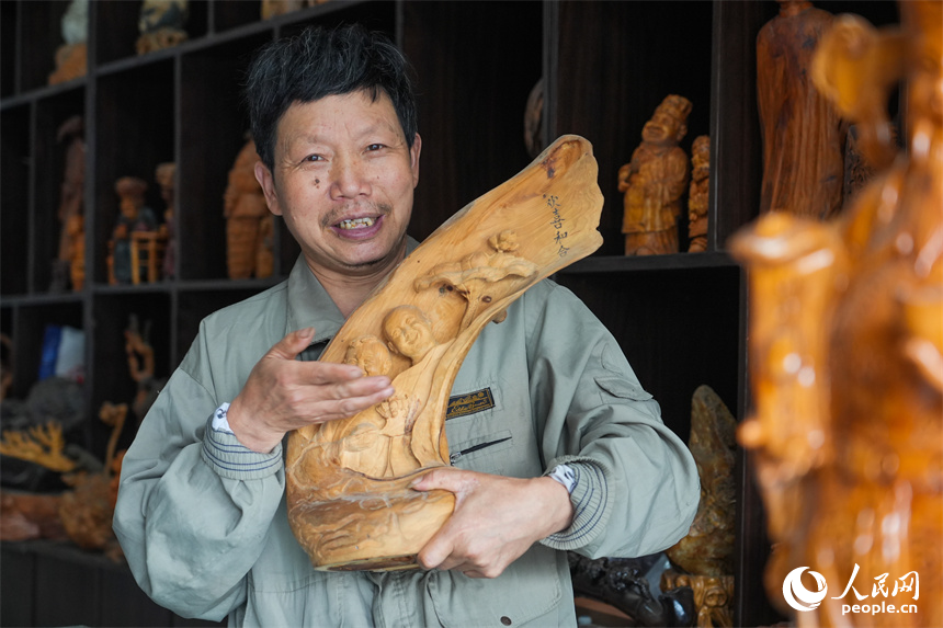 江西省级非遗项目根雕代表性传承人刘四喜和他的根雕作品。人民网 孔文进摄