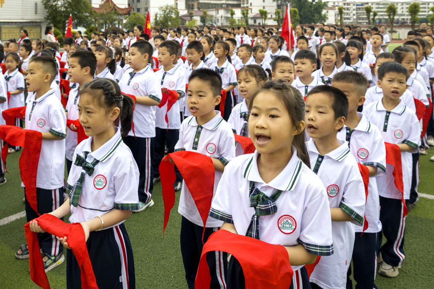 5月28日，江西省吉安市吉水縣吉水實驗小學，即將入隊的學生手捧鮮艷的紅領巾，齊聲高唱中國少年先鋒隊隊歌。 廖敏攝