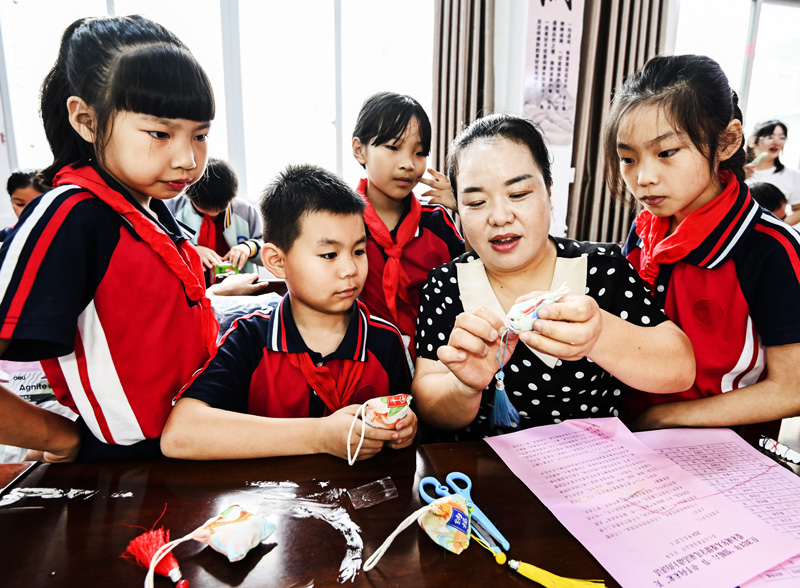 江西省勞動模范李銀香（右二）在撫州市資溪縣第三小學指導學生制作香囊。吳志貴攝