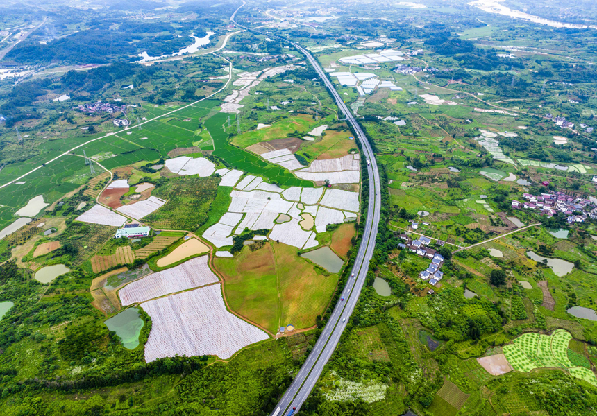 航拍江西省抚州市南丰县洽湾镇长岭村，济广高速公路与中药材种植基地、乡村道路、村庄等相互映衬，构成了一幅美丽的乡村振兴画卷。谢东摄