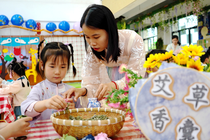 孩子們正在老師的指導下學做艾草香囊。陳旗海攝