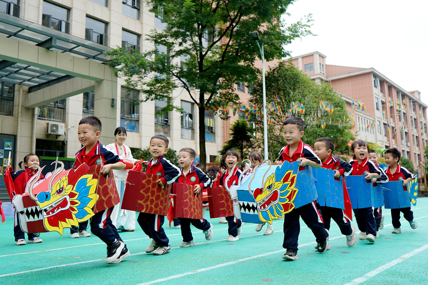 孩子们正在玩赛旱龙舟的游戏。陈旗海摄