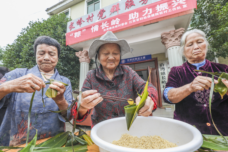 江西省抚州市南丰县洽湾镇长岭村党群服务中心，老人们正在进行包粽子比赛。谢东摄