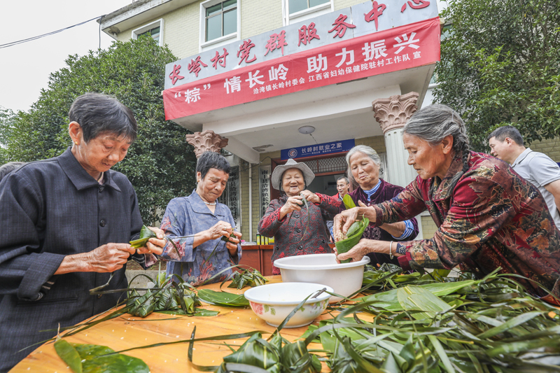 江西省抚州市南丰县洽湾镇长岭村党群服务中心，老人们正在进行包粽子比赛。谢东摄