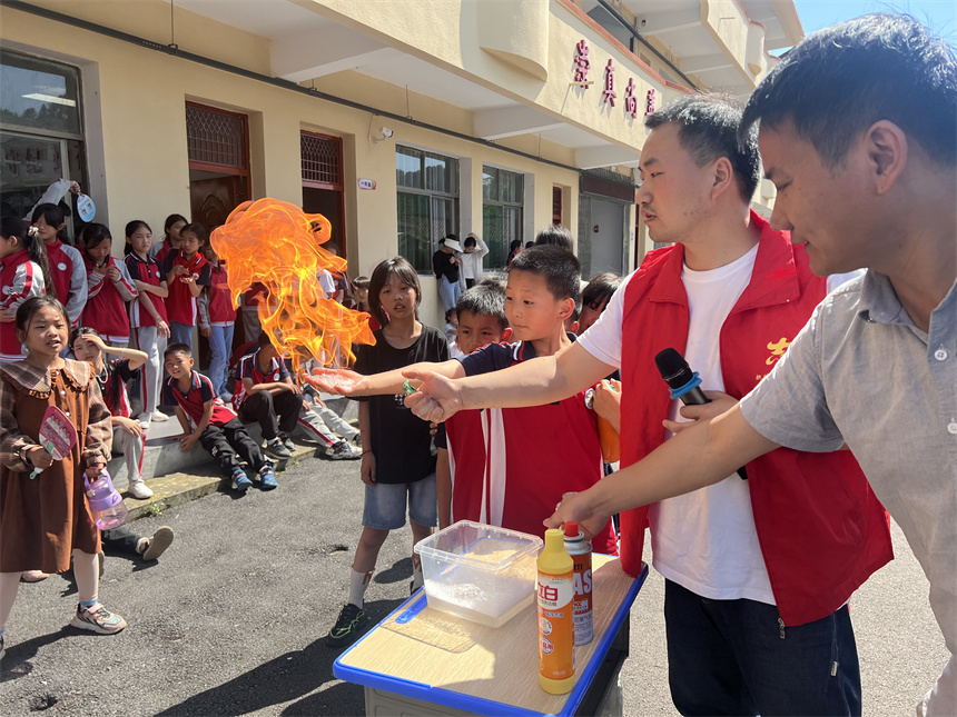 资溪县嵩市中心小学学生体验“火焰掌”科学实验。潘欣意摄 