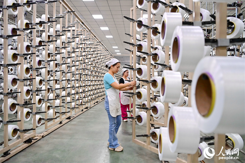 贛州市瑞金經濟技術開發區的一家紡織公司，紡織工人在織造車間加工出口服飾紡線訂單產品。人民網 朱海鵬攝