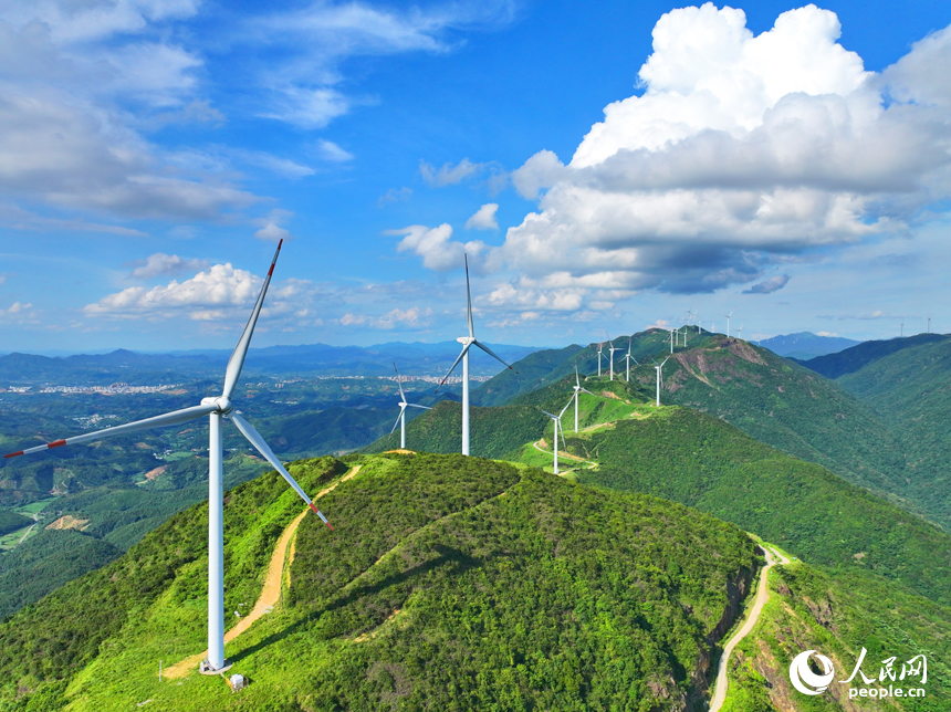 赣州市安远县九龙山风力发电场，随风转动的发电机组与蓝天、白云、绿树、青山交相辉映。人民网 朱海鹏摄