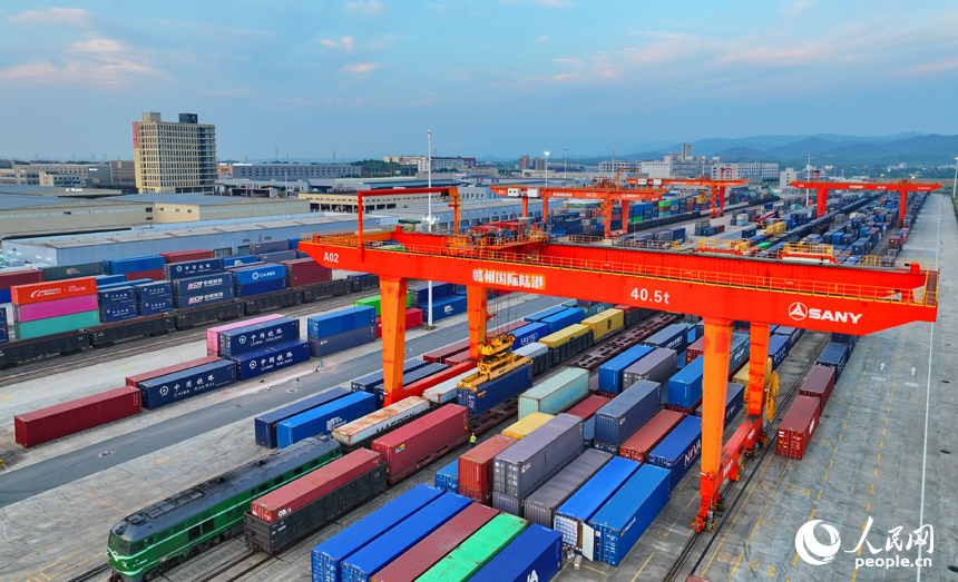 贛州國際陸港貨場作業繁忙，貨物集裝箱層層碼放，滿載出口產品的中歐班列貨運列車在有序裝箱。人民網 朱海鵬攝
