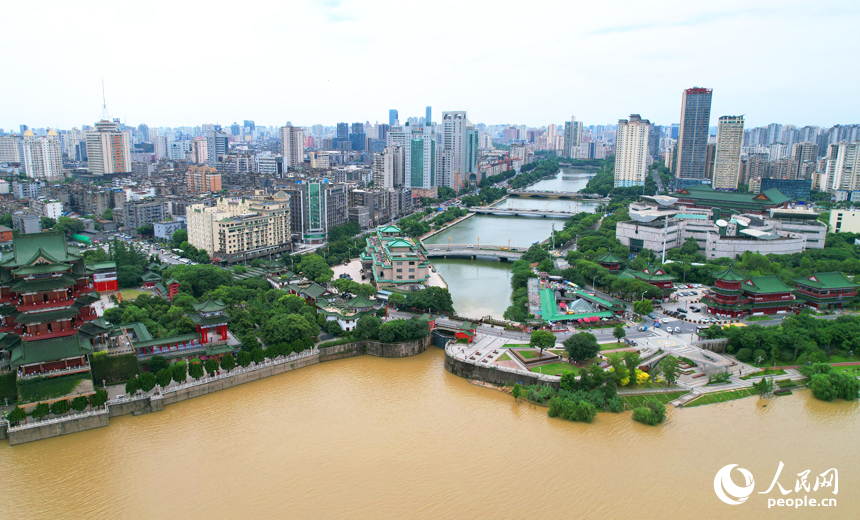 渾濁的江水與城市內河形成對比。人民網記者 毛思遠攝