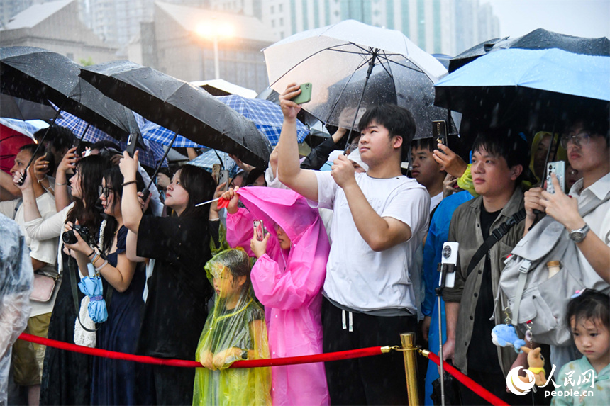 市民和游客冒著大雨觀看升國旗儀式。人民網記者 時雨攝