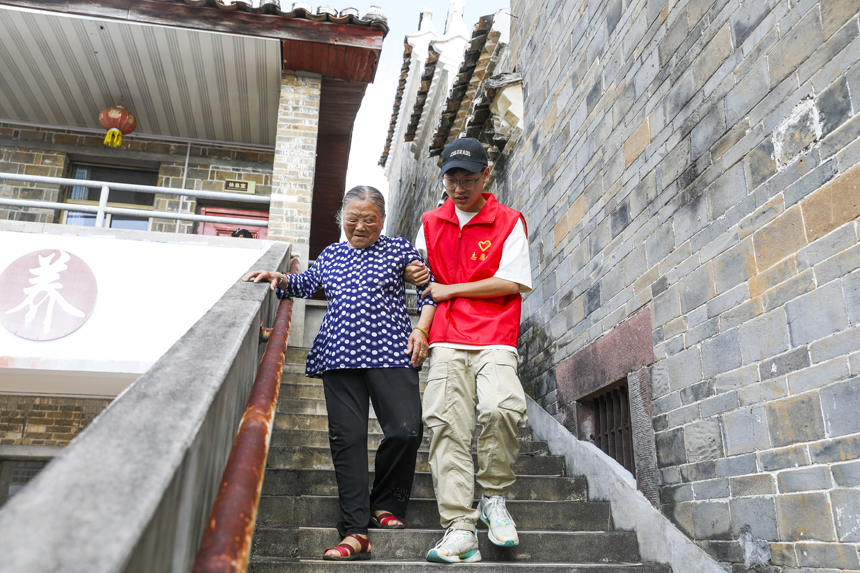 7月3日，江西省抚州市南丰县市山镇包坊村“一老一小”幸福院内，志愿者在照顾老人起居。谢东摄