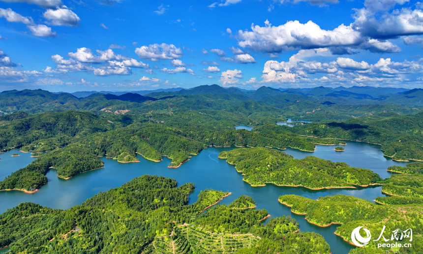 赣州市会昌县石壁坑水库波光粼粼，蓝天白云与澄净湖水交相辉映，构成一幅绿色生态山水画卷。人民网 朱海鹏摄