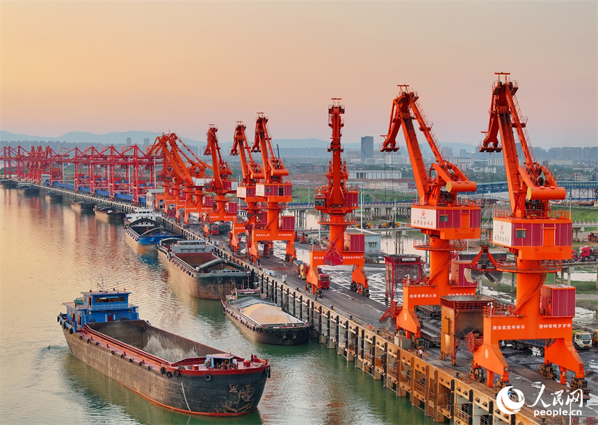 位于南昌市南昌县的姚湾综合码头，货船、货车来来往往，起重机装卸作业有序进行，呈现出忙碌的景象。人民网 朱海鹏摄