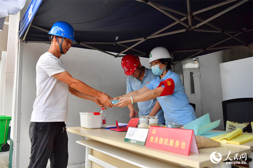 糧農工作人員正在為運糧車司乘人員發放早餐。人民網記者 時雨攝