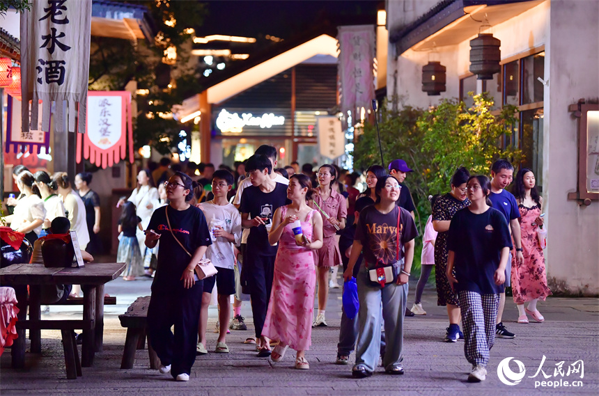 游客们在小镇古街信步闲游，赏景购物。人民网记者 时雨摄