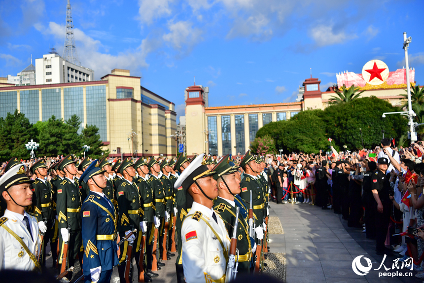 升旗儀式結束后，市民和游客與國旗護衛隊近距離接觸。人民網記者 時雨攝