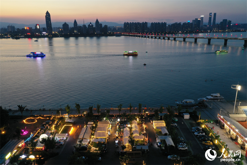 夜幕下，临近赣江的夜市灯光璀璨，江面上游轮游弋，两岸夜景美不胜收。人民网记者 时雨摄